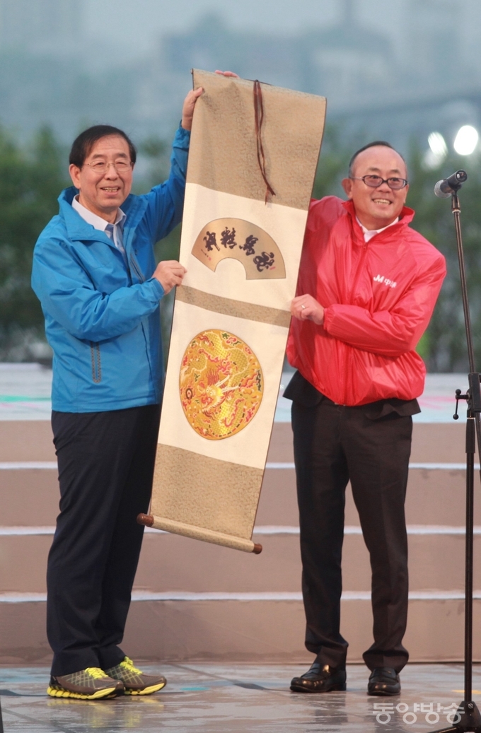 박원순 서울시장이 6일 오후 서울 서초구 반포한강시민공원 달빛광장에서 열린 삼계탕 파티에 참석해 중국 중마이 그룹 리다빙 총재로부터 족자를 선물 받고 있다./사진=장건섭 기자