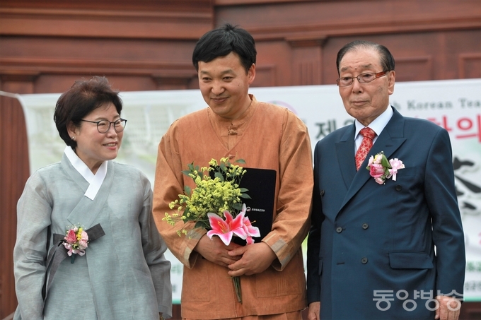 지난 25일과 26일 이틀간 서울 여의도 국회 잔디마당에서 열린 제9회 ‘대한민국 올해의 명다기 품평' 대회에서 대상(문화체육부 장관상)을 수상한 경남 밀양시 초동면에 있는 '토야요(土也窯)'의 송승화(50) 사기장(가운데)이 지난 25일 오후 수상식 직후 박권흠 (사)한국차인연합회 회장(오른쪽)과 최순애 부회장과 함께 기념촬영을 하고 있다./사진=장건섭 기자