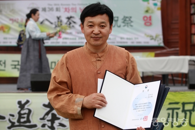 지난 25일과 26일 이틀간 서울 여의도 국회 잔디마당에서 열린 제9회 ‘대한민국 올해의 명다기 품평' 대회에서 다완부문에서 대상(문화체육부 장관상)을 수상한 경남 밀양 '토야요(土也窯)'의 송승화(50) 사기장이 상장을 펼쳐보이고 있다./사진=장건섭 기자