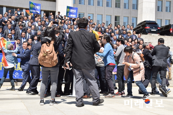 문재인 더불어민주당 대선후보가 26일 국회 본청 계단 앞에서 열린 '천군만마 국방안보 1000인 지지선언' 기자회견에서 인사말을 하는 도중 성 소수자의 인권을 상징하는 '무지개 깃발'을 든 동성애자들이 항의구호를 외치며 문 후보에게 달려들고 있다./사진=국회연합기자단