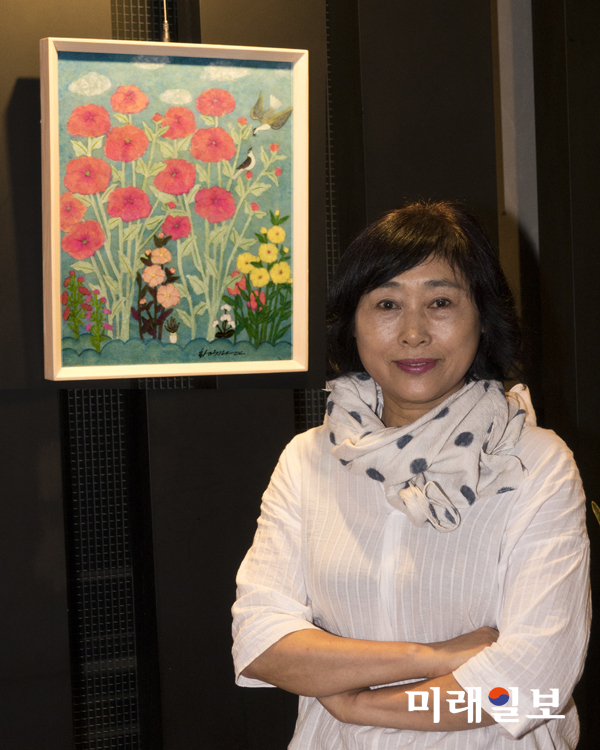 한국화의 채색기법으로 민화를 재해석, 작가만의 독특한 기법을 담은 우현 황치남 작가 개인전이 서울 강남구 삼성동 '치폴라로쏘' 삼성점 갤러리 초대로 오는 31일까지 열리고 있는 가운데 황 작가가 자신의 작품 앞에서 포츠를 취하고 있다./사진=치폴라로쏘 삼성점 갤러리 제공