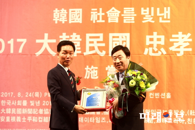 24일 오후 서울 백범 김구기념관에서 개최된 '한국 사회를 빛낸 2017 대한민국충효대상' 시상식에서 '평소 확고한 국가관으로 봉사와 효'를 실천한 공로를 인정받아 행정공직부문 '2017 우수지방행정발전공로 대상'을 수상한 김주수 경북 의성군수를 대신해서 변화원 의성군 기회실장(오른쪽)이 수상을 하고 있다./사진=의성군청 제공