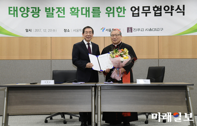 박원순 시장과 염수정 추기경이 27일 오전 서울시청에서 ’태양광 발전 확대를 위한 업무협약‘ 협약서에 서명한 뒤 포즈를 취하고 있다./사진=서울시 제공