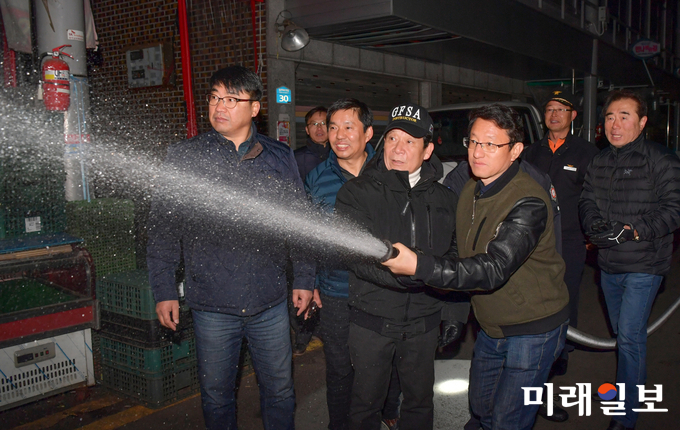 윤장현 광주광역시장이 지난해 11월 18일 저녁 북구 말바우시장을 찾은 윤장현 시장이 관내 소방대원 및 상인대표와 함께 시장 내 설치된 비상소화전으로 물을 뿌려보고 있다. / 사진=광주시 제공