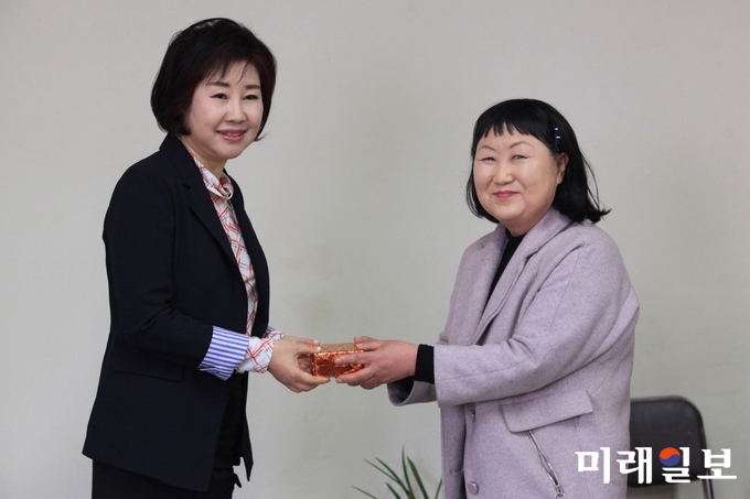 성명순 수원예술학교 신임 교장(왼쪽)이 20일 오전 수원시 장안구 정조로 수원예총 회의실에서 개최된 수원예총 부설 '수원예술학교' 교장 취임식에서 축하객으로부터 기념품을 선물 받고 있다./사진=장건섭 기자