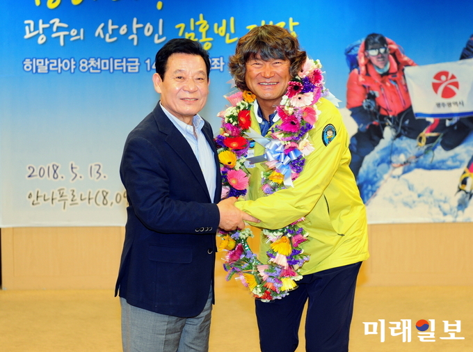 김홍빈 대장이 열 손가락이 없는 장애를 딛고 세계 제10위의 고봉 안나푸르나(8,091m) 등정에 성공한 뒤 윤장현 광주시장으로부터 환영의 꽃다발을 받고 있다. / 사진=광주시 제공
