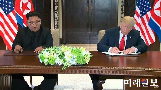 도널드 트럼프 미국 대통령과 김정은 북한 국무위원장이 12일 싱가포르 센토사섬 카펠라호텔에 정상회담을 갖고 공동합의문에 서명하고 있다./사진=백악관 트위터