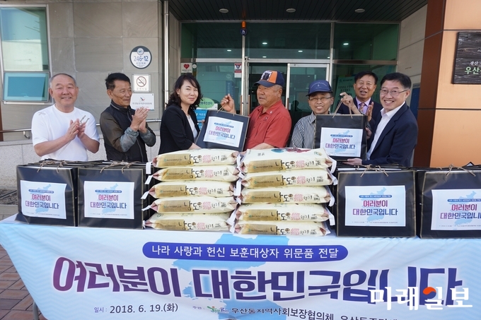 광주 우산동 지사협이 19일 보훈대상 가정 20세대를 찾아 샴푸세트와 쌀 10kg을 각각 전달했다. / 사진=광산구 제공