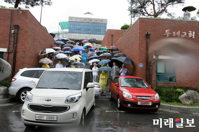 1일 이문장 목사 측 신도들이 교회 본당으로 들어갈 수 있는 정문을 3대의 차량으로 막고 있는 가운데 계단에는 100여 명의 이문장 목사 측 신도들이 촘촘히 서서 출입을 봉쇄하고 있다./사진=인터넷언론인연대