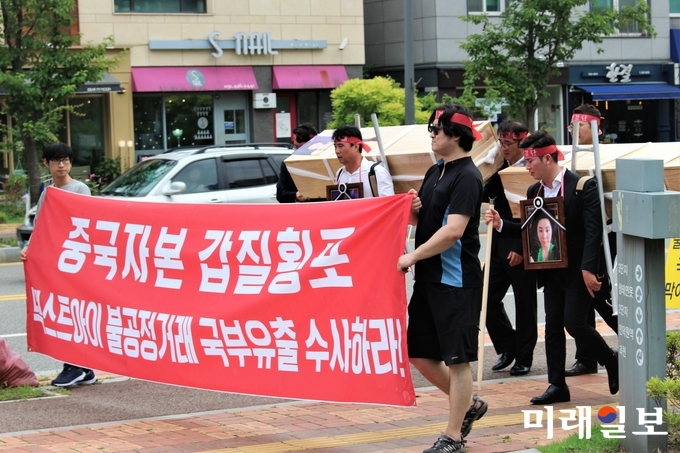 김영석 HS글로벌 대표(지게에 관을 멘 왼쪽)와 김주영 유미소향 대표(지게에 관을 멘 오른쪽)가 11일 넥스트아이 본사 앞에서 '넥스트아이 진광 대표와 넥스트아이가 최대주주로 있는 HD PRO 진양 대표의 사진을 붙인 관'을 메고 행진하고 있다./사진=김정현 기자