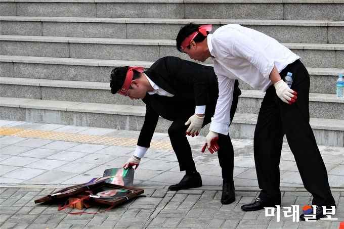 김영석 HS글로벌 대표와 김주영 유미소향 대표가 11일 넥스트아이 본사 앞에서 넥스트아이 진광 대표와 넥스트아이 진양 이사의 '영정사진'에 불을 붙이고 있다./사진=김정현 기자