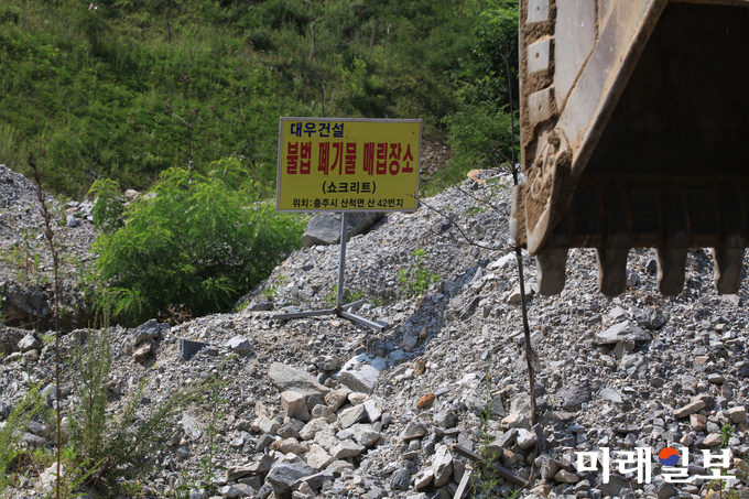 지난 7월 17일 대우건설이 충주-제천간 동서고속도로 건설공사(제3공구) 과정에서 운영했던 충주시 산척면 산 42번지 소재 사토장에서 법원 감정인에 의한 현장 감정이 진행된 가운데 토지주가 주장하고 있는 '대우건설 불법 폐기물 매립장소' 푯말이 세워져 있다./사진=장건섭 기자