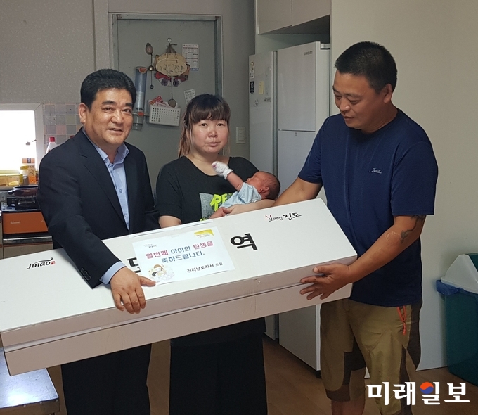 문동식 전남 보건복지국장이 5남 5녀를 둔 영광군 군서면 덕산리에 사는 최난희, 김용희씨 부부를 6일 방문해 격려하고 신생아 양육비 30만원과 축하용품 등을 전달하고 있다. / 사진=전남도 제공