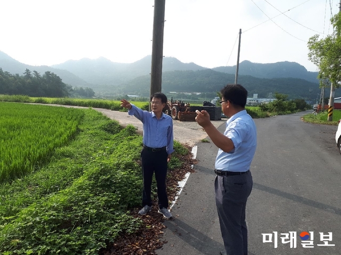 이승옥 강진군수가 지난 11일 농업용수가 가장 많이 필요한 벼 출수기 현장을 방문해 강우량 확인과 앞으로 농업용수 확보 방안에 대해 도암면 귀라마을 이장과 의논하고 있다. / 사진=강진군 제공