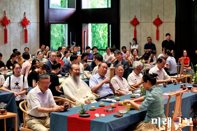 18일 오전(현지시간) 중국 절강성 황저우시 중국차엽박물관에서 열리고 있는 광주조선왕실의 도예 명장 연파 신현철 선생의 '시광여연(时光如蓮)-신현철 도예 다구전' 개막식에서 주국부(周国富) 중국국제차문화연구회 회장(왼쪽에서 세 번째)가 연파 신현철 명장을 비롯 중국의 정·관계 및 차계 인사 등과 함께 개막식에 참석하고 있다./사진=장건섭 기자