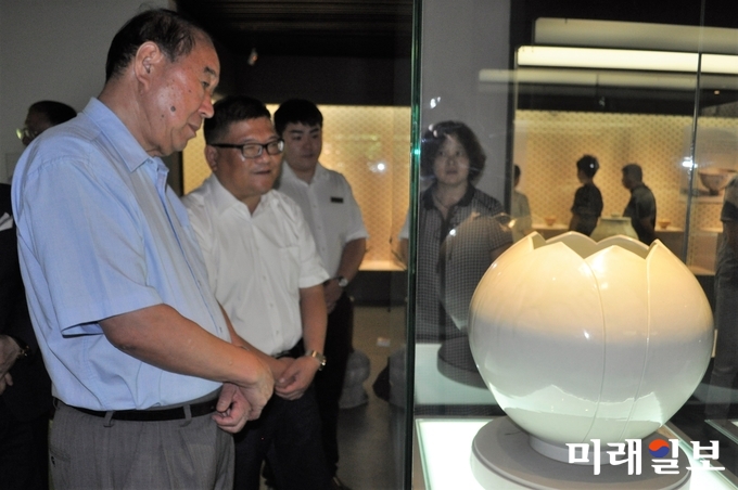 18일 오전(현지시간) 중국 절강성 황저우시 중국차엽박물관에서 열리고 있는 광주조선왕실의 도예 명장 연파 신현철 선생의 '시광여연(时光如蓮)-신현철 도예 다구전' 개막식에서 주국부(周国富) 중국국제차문화연구회 회장이 오효력(吳曉力) 중국차엽박물관 관장 등과 함께 연파 신현철 명장의 전시 도예 작품을 감상하고 있다./사진=장건섭 기자