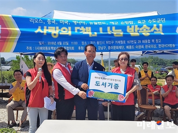 (사)해외동포책보내기운동협의회는 22일 오전 경기도 용인시 처인구 원삼면 가재월로 협회 책 창고에서 2018년 해외동포와 국내 소외 지역에 보낼 도서 발송식과 기증식을 갖고 있는 가운데 신순정 한류위원회 회장(오른쪽 맨끝)이 박현옥 캄보디아 회장을 대신해 손석우 이사장(왼쪽에서 세 번째)으로부터 도서를 기증 받고 있다./사진=한류위원회 제공
