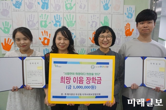 광주 광산구 우산동 지역사회보장협의체가 23일 동 행정복지센터에서 새 학기를 맞은 배려계층 청소년 2명에게 각각 장학금 50만원씩을 전달했다. / 사진=광산구 제공
