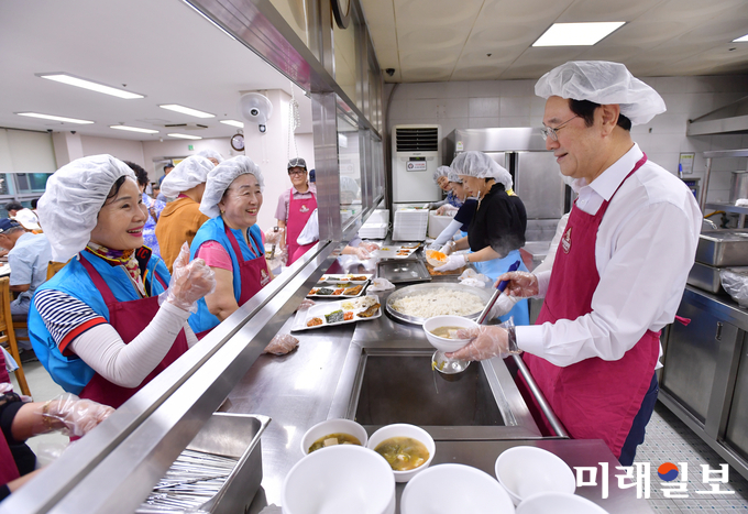 이용섭 광주광역시장이 6일 정오 서구 화정동 노인종합복지관을 방문해 어르신들에게 배식봉사를 하고 있다./사진=광주시 제공