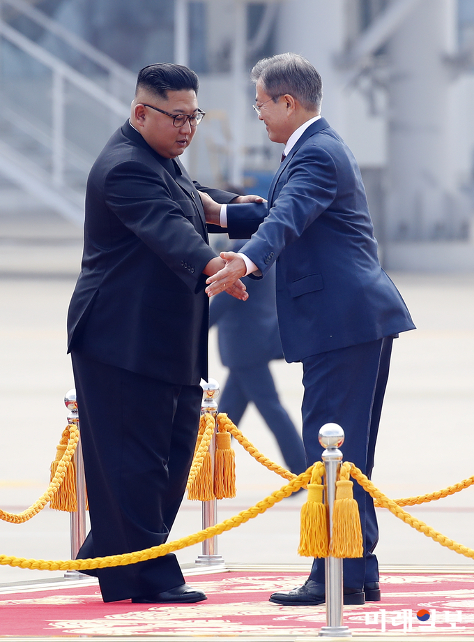 문재인 대통령과 김정은 국무위원장이 18일 오전 평양 순안공항에서 열린 공식환영식에서 의장대 사열을 마친 뒤 서로 먼저 계단을 내려가라고 권유하고 있다./사진=평양사진공동취재단