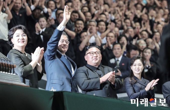 문재인 대통령과 김정은 국무위원장이 19일 밤 평양 5.1경기장에서 열린 남북정상회담 경축 대집단체조와 예술공연 '빛나는 조국'에 입장한 뒤 손을 들어 인사하고 있다./사진=평양사진공동취재단