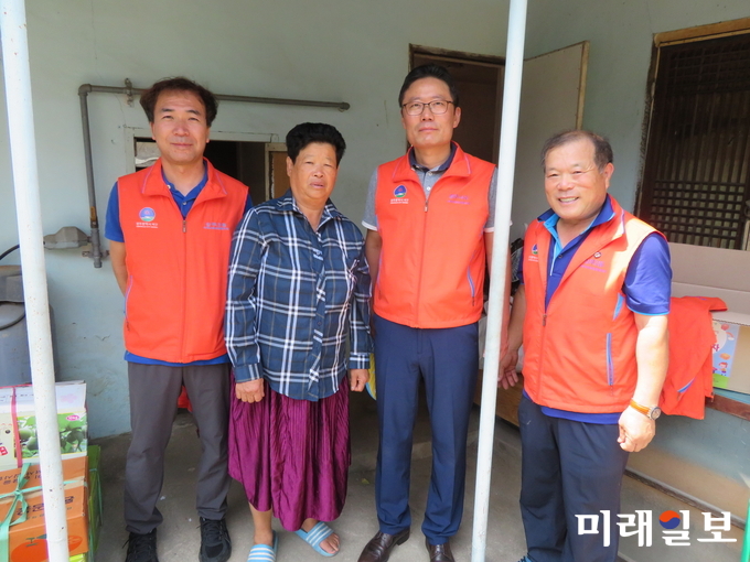 이용철 광주 서구 상무2동장(왼쪽에서 3번째)이 김길수씨에게 생필품을 전달하고 있다. / 사진=이용희 제공