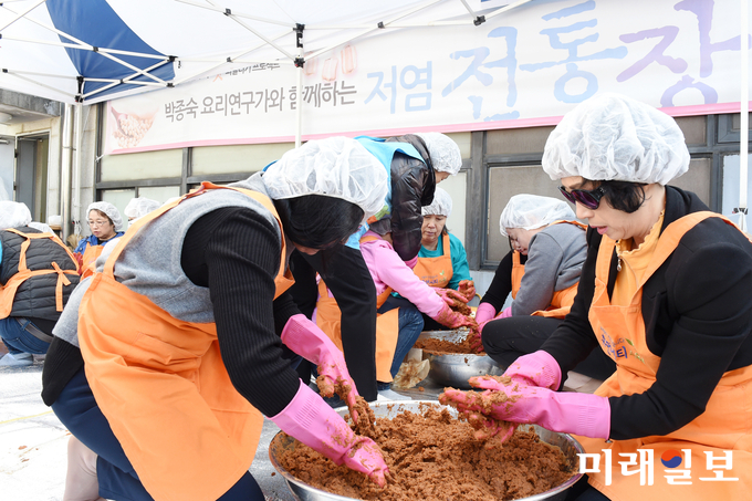 수원시청 옥상 장독에서 숙성된 저염 된장을 ‘전통 저염장 담그기 체험 교육’ 수강생들이 ‘장 리뉴얼’ 작업을 하고 있다./사진=수원시 제공
