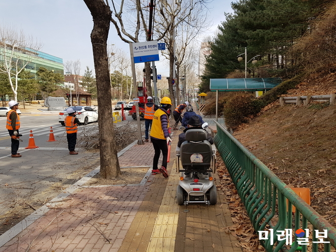 보행안전도우미들이 공사현장 인근에서 시민들에게 임시통행로를 안내하고 있다./사진=수원시 제공
