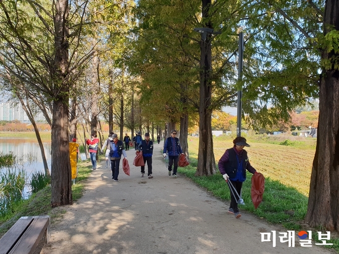 시민들이 일월공원에서 ‘공원 클린데이’ 행사에 참여해 쓰레기를 수거하고 있다./사진=수원시 제공
