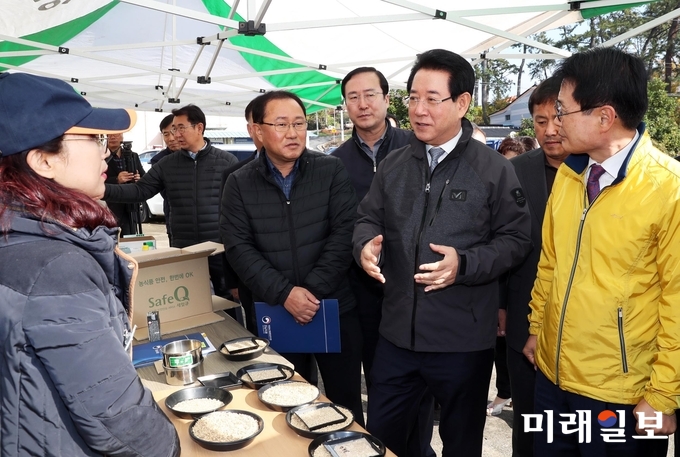 김영록 전라남도지사가 이승옥 강진군수와 함께 12일 오전 공공비축미 매입현장인 강진군 강진읍 서성리를 방문, 국립농산물품질관리원 강진사무소 감정실 관계자로부터 수분측정 등 벼 매입 과정에 대해 설명을 듣고 있다. 올해 전남지역 공공비축미 매입량은 벼 기준 총 12만 4천톤으로 전국 48만톤의 48% 수준이다. / 사진=전남도 제공