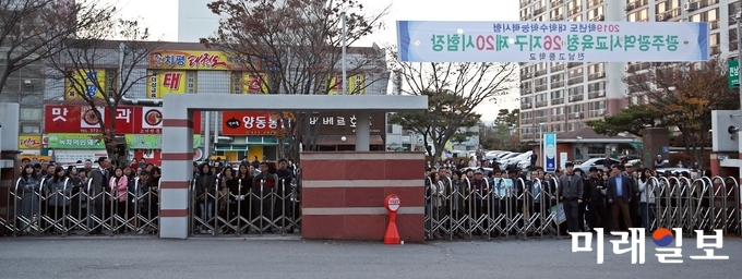 광주 전남고등학교 정문 앞에서 수험생들이 시험이 끝나기를 기다리는 장휘국 교육감과 학부모들 / 사진=광주시교육청 제공