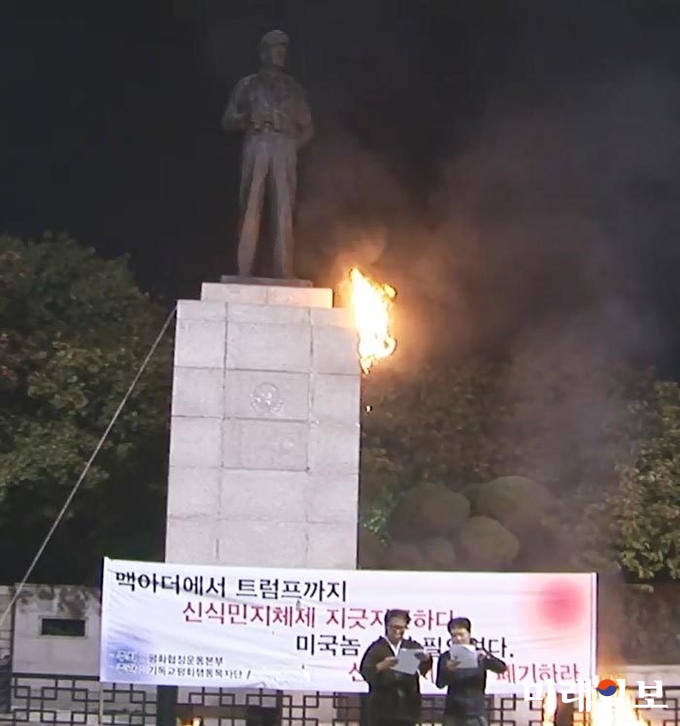 지난달 23일 평화협정운동본부의 반미실천단장 이적 목사(왼쪽)이 인천 중구 자유공원에 있는 맥아더 장군 동상에 불을 지르고 선언문을 낭독하고 있다./사진=평화협정운동본부 제공