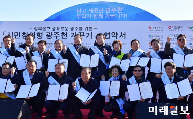 이용섭 광주광역시장이 22일 오전 서구 광천동 광암교 인근 둔치에서 열린 '시민참여형 광주천 가꾸기 발대식'에 참석해 26개 기관·단체장들과 협약서에 서명한 뒤 기념촬영을 하고 있다./사진=광주시 제공
