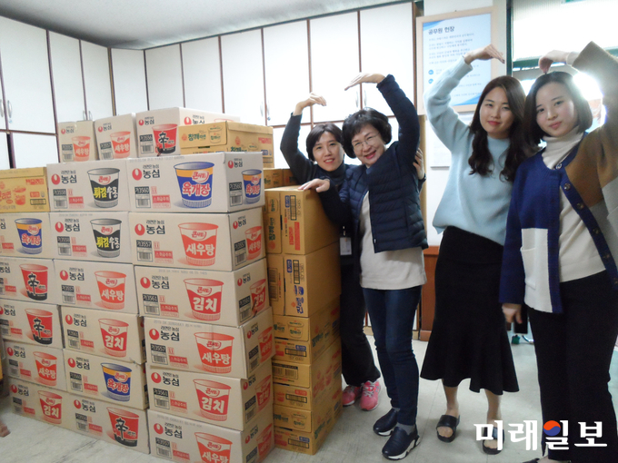 광주 광산구 월곡1동 공직자들이 라면 상자 앞에서 ‘하트’를 그려 기부자에게 감사 인사를 보내고 있다. / 사진=광산구 제공