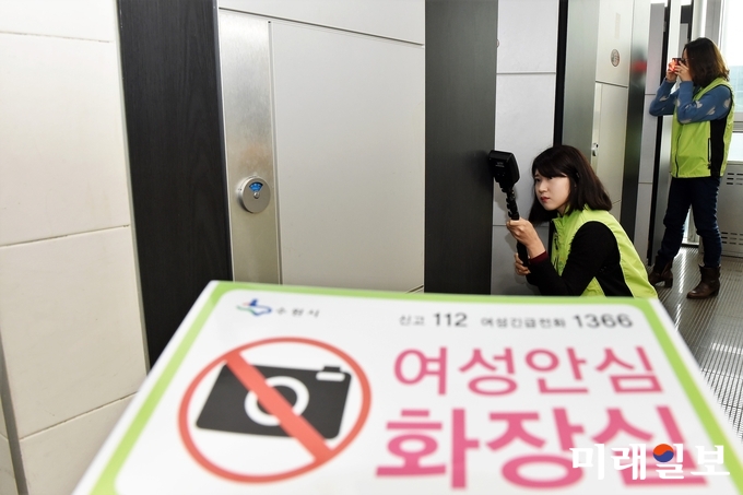 수원시 공중화장실 관리 담당자들이 전파탐지기와 렌즈탐지기를 활용해 불법촬영카메라를 점검하고 있다./사진=수원시 제공