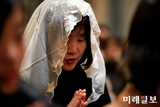 성탄절인 25일 새벽 서울 중구 명동성당에서 열린 자정 미사에서 한 카톨릭 신자가 예수 탄생을 축하하는 기도를 하고 있다./사진=장건섭 기자