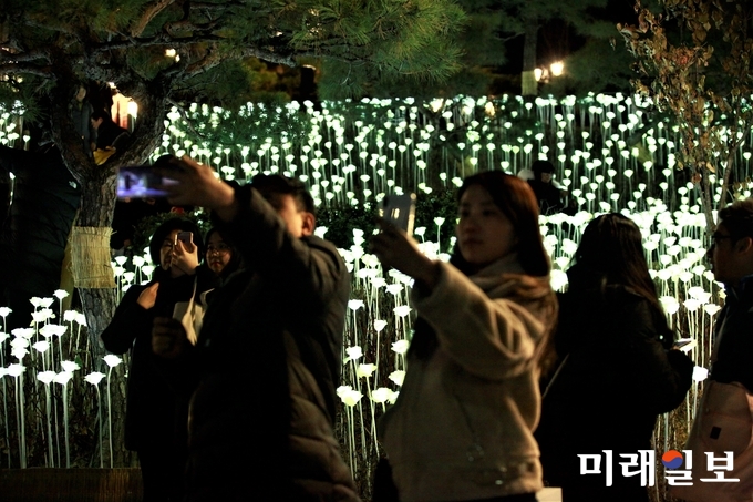 성탄절인 25일 새벽 서울 중구 명동성당 앞에 설치된 LED 장미꽃을 배경으로 신도와 시민들이 기념촬영을 하고 있다./사진=장건섭 기자