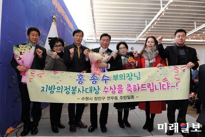 홍중수 경기도 수원시의회 부의장(가운데)이 21일 대전광역시 라도무스아트센터에서 열린 전국 시군자치구 의회의장 협의회 정기총회에서 협의회가 수여하는 ‘제11회 의정봉사대상’을 수상하고 지지자들과 파이팅을 외치고 있다./사진=수원시의회 제공
