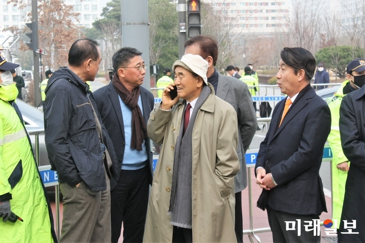 뇌물·횡령 등 혐의로 1심에서 징역 15년을 선고받은 이명박 전 대통령이 6일 항소심에서 보석(보증금 등 조건을 내건 석방)으로 풀려나게 되자 이재오 자유한국당 상임고문이 이동관 전 청와대 홍보수석 등 측근들과 함께 서울 동부구치소 앞에서 이 전 대통령의 출소를 기다리며 전화 통화를 하고 있다./사진=홍재현 기자