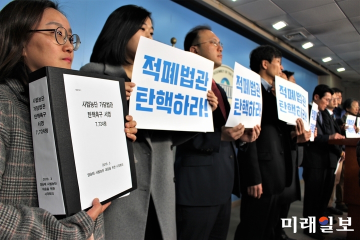 11일 오전 국회 정론관에서 열린 사법농단 가담 법관 탄핵 촉구 기자회견에서 한 참석자가 '사법농단 가담법관 탄핵촉구'에 뜻을 함께하는 7,724명의 서명지를 들고 있다./사진=김정현 기자