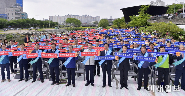 이용섭 광주광역시장이 30일 오후 광주천 두물머리나루에서 열린 2019광주세계수영대회 마스코트 수리·달이와 함께 하는 '광주천 가꾸기 시민한마당' 행사에 참석해 52개 기관·단체와 함께 세계수영대회의 성공을 기원하고 있다. / 사진=광주시 제공