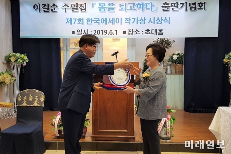 1일 오후 부천시 상동 초대홀에서 열린 이길순 수필집 '몸을 퇴고하다' 출판기념회 및 제7회 한국에세이작가상 시상식에서 이길순 수필가(오른쪽)가 권대근 문학평론가(대신대학원대학교 교수)로부터 제7회 한국에세이작가상을 수상하고 있다./사진=에세이문예사 제공