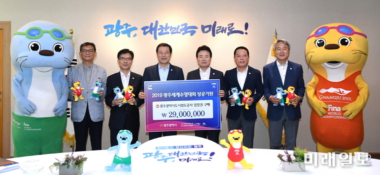 이용섭 광주광역시장이 24일 오전 시청 3층 접견실에서 열린 ‘수영대회 입장권 구매증서 전달식’에서 윤진보 광주도시철도공사 사장으로부터 입장권 구매증서를 전달 받고 기념촬영을 하고 있다. / 사진=광주시 제공