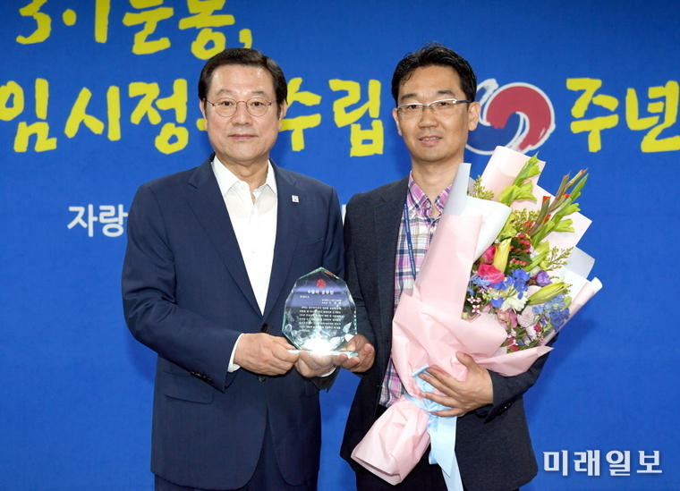 이용섭 광주광역시장이 2일 오전 시청 3층 중회의실에서 ‘6월 이달의 공무원’으로 선정된 이세현 주무관(지방시설주사)에게 시상을 한 후 기념촬영을 하고 있다./사진=광주시 제공