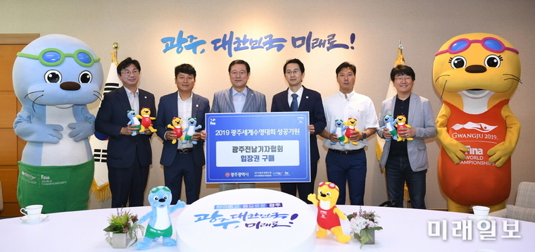 이용섭 광주광역시장이 4일 오전 시청 3층 접견실에서 열린 ‘수영대회 입장권 구매증서 전달식’에서 김효성 광주전남기자협회장으로부터 입장권 구매증서를 전달받고 기념촬영을 하고 있다. / 사진=광주시 제공