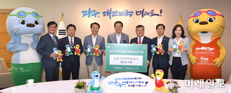 이용섭 광주광역시장이 5일 오후 시청 3층 접견실에서 열린 ‘수영대회 입장권 구매증서 전달식’에서 최창학 한국국토정보공사 사장으로부터 입장권 구매증서를 전달 받고 기념촬영을 하고 있다. / 사진=광주시 제공