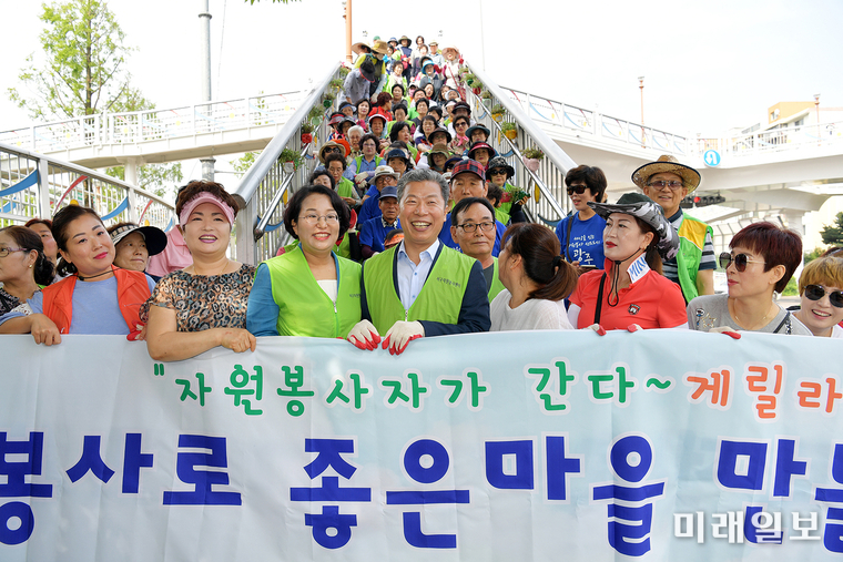 서대석 광주 서구청장이 지난 5일 자원봉사캠프와 자원봉사단체 리더자들과 함께 염주체육관 정문 육교 난간위에 화분을 설치하는 행사를 가졌다. / 사진=서구 제공