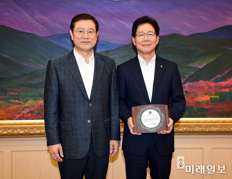 이용섭 광주광역시장이 1일 오전 시청 3층 대회의실에서 '시민참여형 광주천 가꾸기' 사업 우수단체에 선정된 광주은행 마재필 부행장에게 표창장을 수여한 뒤 기념촬영을 하고 있다./ 사진=광주시 제공
