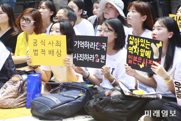 14일 오후 서울 종로구 옛 일본대사관 앞에서 열린 제 1400차 일본군 성노예제 문제 해결을 위한 정기 수요집회에 참석한 시민들이 피켓을 들고 있다./사진=장건섭 기자