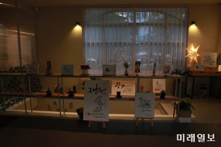 피오르 2층으로 오르는 계단과 숍에 전시된 캘리그라피 동아리 회원들의 작품들 / 사진=이중래 기자